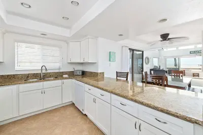 a kitchen with white cabinets and a large counter top at Spacious Oceanfront Home Near Newport Pier in Newport Beach