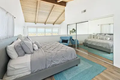 a bedroom with a large bed and a large window at Spacious Oceanfront Home Near Newport Pier in Newport Beach