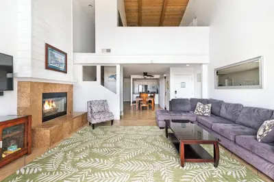 a living room with a couch and a fireplace at Spacious Oceanfront Home Near Newport Pier in Newport Beach