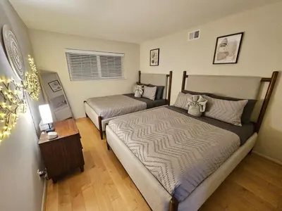 a bedroom with two beds and a table with a lamp at La Jolla Gem with Ocean View - 11 Beds, Hot Tub, Karaoke & Game Den in San Diego