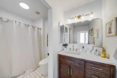 a bathroom with a sink and a toilet and a mirror at BoHo Beach House Walk to the Sand in San Diego