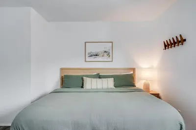 a bedroom with a large bed with green sheets at BoHo Beach House Walk to the Sand in San Diego