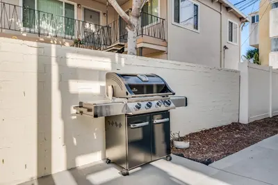 a grill in front of a building with a house at BoHo Beach House Walk to the Sand in San Diego