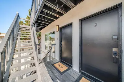 a staircase leading to a door with a sign on it at Boho Beach Bungalow Walk to the Beach in San Diego