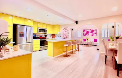 a kitchen with yellow cabinets and a dining room at Casa de Bloom Venue - Your Perfect Event Space in San Diego