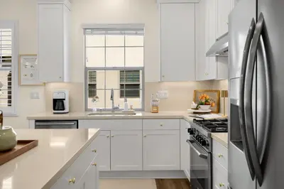 a kitchen with white cabinets and a stainless steel refrigerator at Modern Elegant Designer Home in Irvine in Irvine