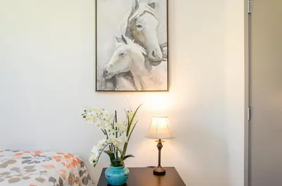 a bedroom with a painting of horses on the wall at Charming 3 Bedroom Apartment with Pool Near San Diego Convention Center in San Diego