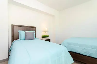 a white bedroom with two beds and a lamp at Charming 3 Bedroom Apartment with Pool Near San Diego Convention Center in San Diego