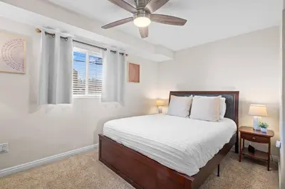 a bedroom with a bed and a ceiling fan at 2 Bdrm Condo + Parking in Heart of Mission Beach! in San Diego