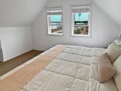 a bedroom with a large bed with two windows at F-72 Terramar Cliffs in Carlsbad