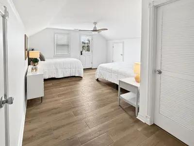 a white bedroom with two beds and a table at F-72 Terramar Cliffs in Carlsbad