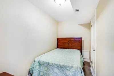 a small bedroom with a bed and a wooden headboard at F-73 Terramar Cliffs in Carlsbad