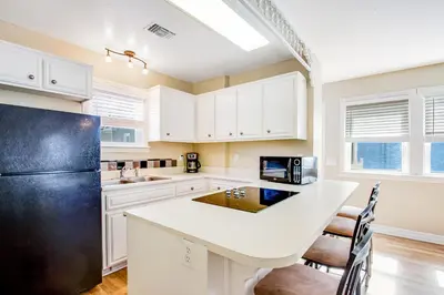 a kitchen with white cabinets and a black refrigerator at F-76 Terramar Cliffs in Carlsbad