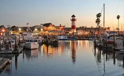 a marina with boats in the water with a lighthouse at Ocean View Roof Deck - Walk to the Beach & Pier in Oceanside