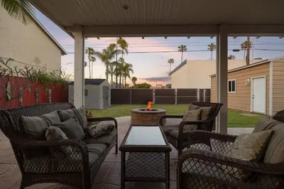 a patio with chairs and a couch and a table at Walk to the Beach Private Backyard and Fire Pit in Oceanside