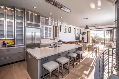 a kitchen with a large island with bar stools at Walk to the Beach Luxury Roof Deck Sunset View in Oceanside