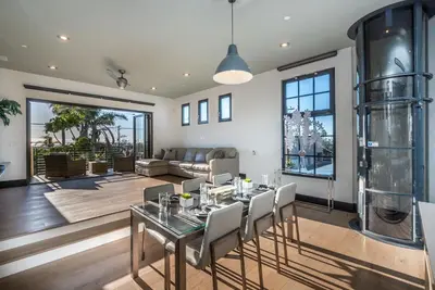 a dining room with a glass table and chairs at Walk to the Beach Luxury Roof Deck Sunset View in Oceanside