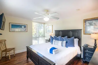 a bedroom with a large bed with blue pillows at Walk to the Beach Pool & Hot Tubs & Gym - A-116 in Oceanside