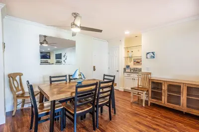 a kitchen and dining room with a wooden table and chairs at Walk to the Beach Pool & Hot Tubs & Gym - A-116 in Oceanside