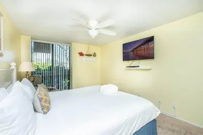 a bedroom with a white bed and a ceiling fan at Steps to the Beach 2 Pools & Hot Tubs - A-204 in Oceanside