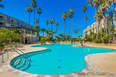 a swimming pool in a resort with palm trees at Steps to the Beach 2 Pools & Hot Tubs - A-204 in Oceanside