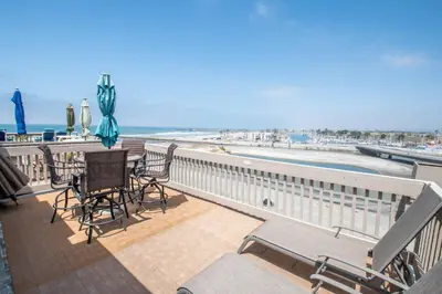 a balcony with a table and chairs and the beach at Penthouse Ocean & Sunset Balcony Views - G-323 in Oceanside