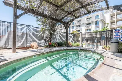 a swimming pool with a pergola next to a building at Penthouse Ocean & Sunset Balcony Views - G-323 in Oceanside