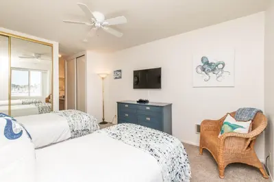 a bedroom with two beds and a ceiling fan at Penthouse Ocean & Sunset Balcony Views - G-323 in Oceanside