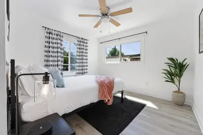 a white bedroom with a bed and a ceiling fan at Luxury Home with Spacious Backyard - Sleeps 12 in Poway