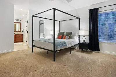 a bedroom with a black canopy bed with a mirror at Hot Tub with A View and Large Back Deck & Game Room in Poway