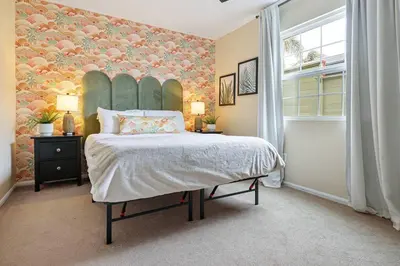 a bedroom with a large bed with a floral wall at 10 Mins to the Beach La Jolla and UCSD in San Diego
