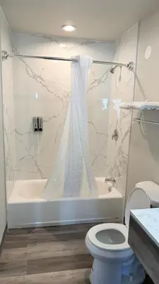 a bathroom with a tub and a toilet and a shower at Broadway Inn and Suites in Chula Vista
