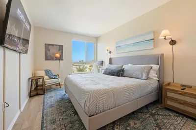 a bedroom with a bed and a chair and a window at Lux North Park Gem King Beds Workspaces Parking in San Diego