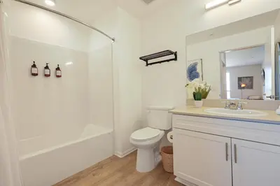 a white bathroom with a toilet and a sink at Lux North Park Gem King Beds Workspaces Parking in San Diego
