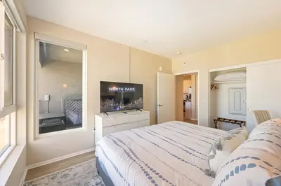 a bedroom with a large bed and a tv at Lux North Park Gem King Beds Workspaces Parking in San Diego