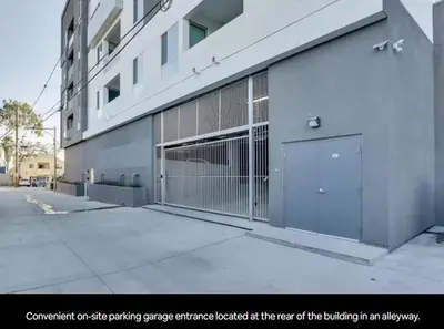 a building with a gate entrance located at the rear of the building at North Park Penthouse King Beds Workspaces Parking in San Diego