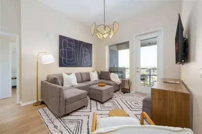 a living room with a couch and a tv at Lux N Park Penthouse King Beds Workspaces Parking in San Diego