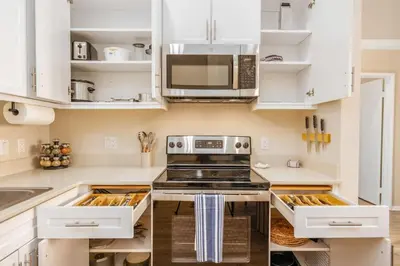 a kitchen with white cabinets and a stove at Lux N Park Penthouse King Beds Workspaces Parking in San Diego
