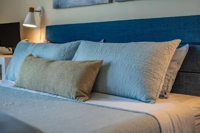 a bed with a blue headboard and pillows on it at Lux N Park Penthouse King Beds Workspaces Parking in San Diego