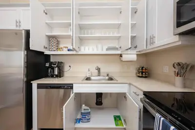 a kitchen with white cabinets and a sink at Lux N Park Penthouse King Beds Workspaces Parking in San Diego