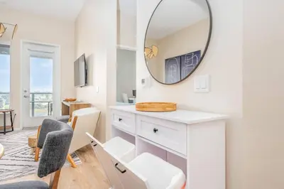 a white room with a mirror and a chair at Lux N Park Penthouse King Beds Workspaces Parking in San Diego