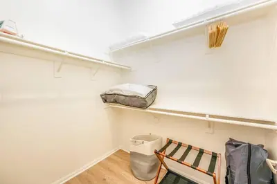 a walk in closet with a bench and a bag at Lux N Park Penthouse King Beds Workspaces Parking in San Diego