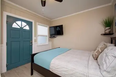 a bedroom with a bed and a blue door at Steps to Newport Harbor Balboa Fun Zone Dock Access Edgewater Studios in Newport Beach