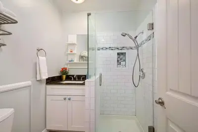 a white bathroom with a shower and a sink at Steps to Newport Harbor Balboa Fun Zone Dock Access Edgewater Studios in Newport Beach