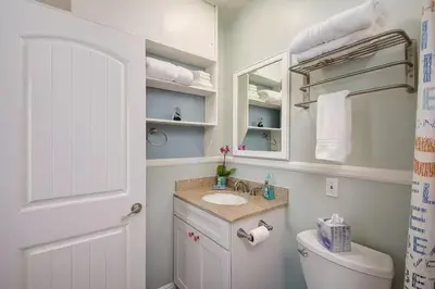 a white bathroom with a sink and a toilet at Steps to Newport Harbor Balboa Fun Zone Dock Access Edgewater Studios in Newport Beach
