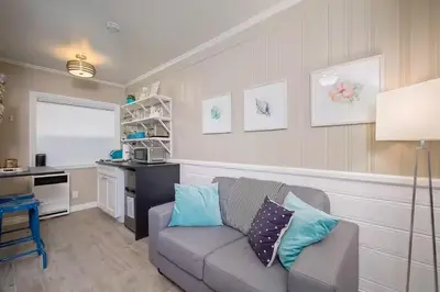 a living room with a couch and a kitchen at Steps to Newport Harbor Balboa Fun Zone Dock Access Edgewater Studios in Newport Beach