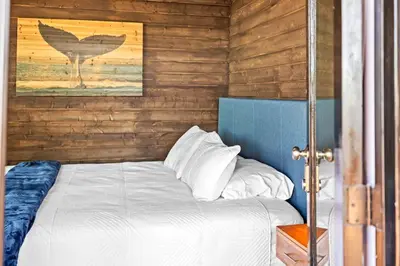 a bed in a room with a wooden wall at Stunning Bay Views with Pickleball and Hot Tub in San Diego