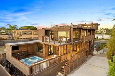 a large house with a deck and a swimming pool at Stunning Bay Views with Pickleball and Hot Tub in San Diego