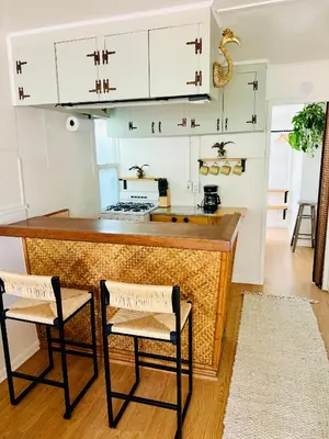 a kitchen with white cabinets and two stools at Casa Luna in San Diego