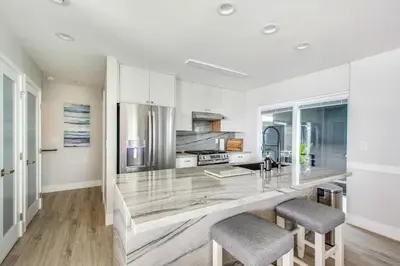 a kitchen with a large counter with two stools at Tower 9 Oceanview House in Oceanside